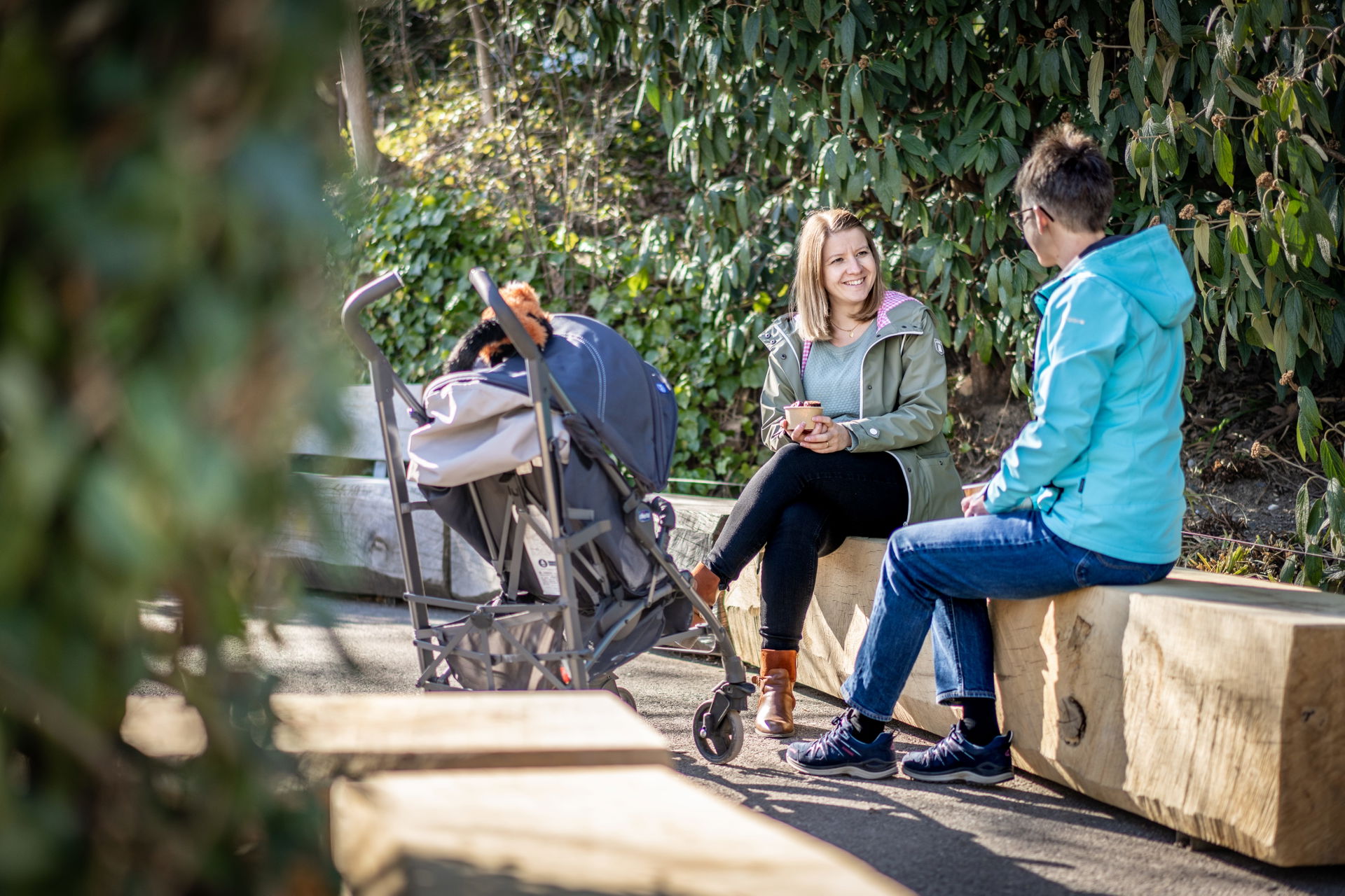Zwei Personen sitzen auf den Spendenbänken im Eingangsbereich des Zoo Zürich.